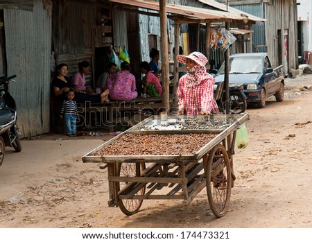 SUBURB SIHANOUKVILLE, CAMBODIA. FEBRUARY 26, 2013 - A woman sells on the street local food