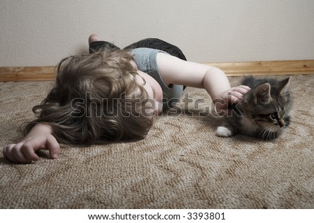 little adorable boy with kitten playing at home