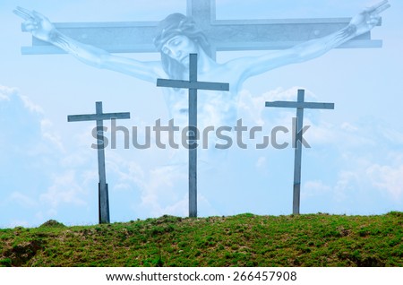 Three wooden crosses on a grassy hill with Jesus on the cross in the clouds in the background.