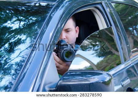 Private investigator on a stakeout is photographing the situation to document the events.