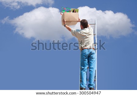 Cloud backup and storage concept showing a man on a ladder putting box of music and photos in cloud for storage