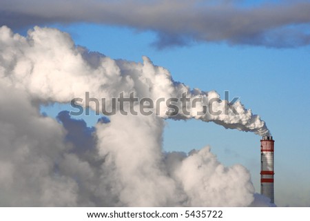 A smoking chimney against a blue sky.