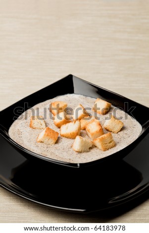 Mushroom cream soup with pieces of toasted bread, room for text.