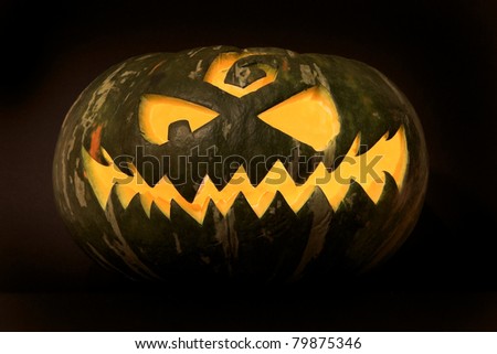 Jack-o\'-lantern, spooky Halloween green pumpkin face.