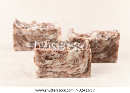 Bars of natural handmade chocolate soap on a linen fabric.
