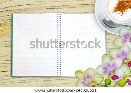 Blank book with coffee and orchid flowers on the wooden table