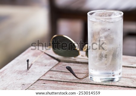 Water in a glass with ice placed on wooden table with glasses for a toast to the health and thirst