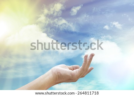 Hand reaching for the sun and sky