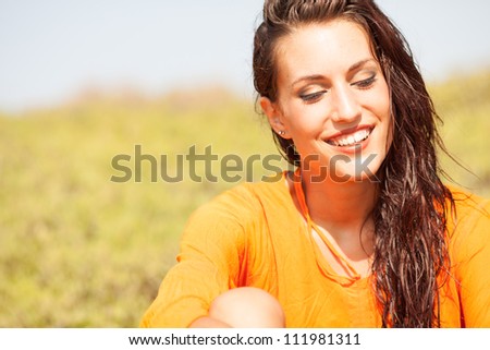 Portrait of young beautiful woman laughing wearing orange shirt