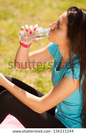 young beautiful sport woman drinking water after sport outdoors