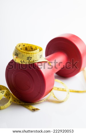 Red dumbbells weight with measuring tape for diet concept on white background