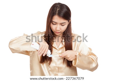 Asian woman in pajamas with toothbrush and toothpaste  isolated on white background