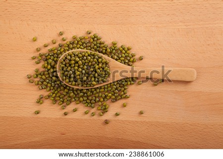 Mung beans with wooden spoon on wood background