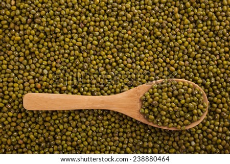 Mung beans with wooden spoon on mung beans background