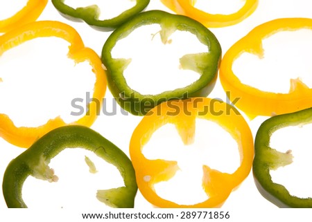 Cut yellow and green bell peppers on white background