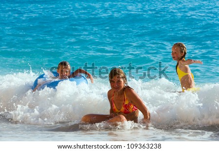 Family (mother with two children) have the water-based recreation on white Egremni beach (Ionian sea, Lefkada, Greece)