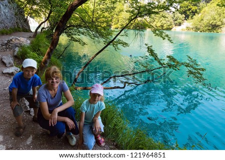 Family near summer azure  limpid  transparent lake (Plitvice Lakes National Park, Croatia)
