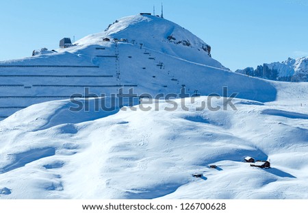 Beautiful winter mountain landscape with ski lift and snow screen on slope (Sella Pass , Italy).