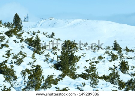 Beautiful winter mountain landscape with ski lift and ski run on slope (all people are unrecognizable)