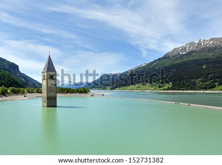 Flooded (in 1950) bell tower in Reschensee and family (Italy, church building in 14th-century)