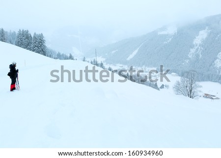 Winter mountain foggy dull day snowy landscape and woman on walk