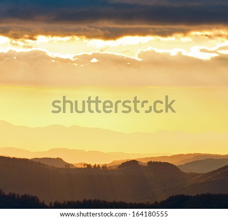 Autumn evening  landscape with lust sunlight on mountains and glow in sky