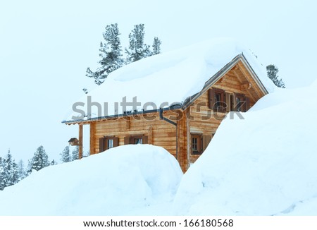 Winter misty mountain  landscape and wood house on hill top.