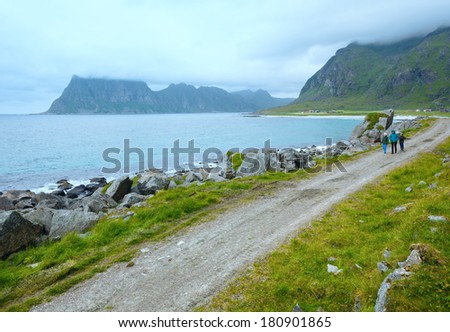 Family walking along Haukland stony beach. Summer view (Norway, Lofoten).