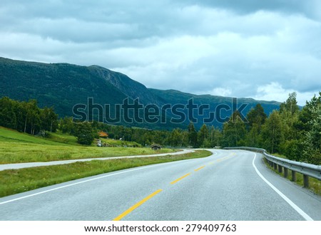 Summer cloudy mountain landscape with road (Norway).
