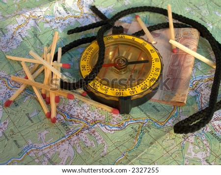 Compass, matches and money on a geographic map (compass displace to up)