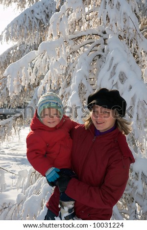 Happy family (mother with small boy) in winter snow covered city park