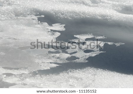 Wind form ice texture on winter mountain snow surface