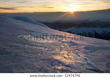 Beautiful mountain sunset landscape with sun way on ice-coated mountainside. (Ukraine, Carpathian Mt's, Svydovets Range)