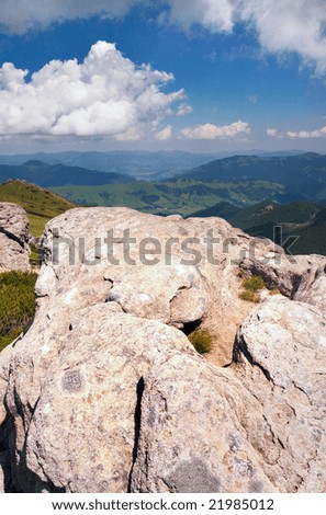 big stone with hollow of big foot form on summer mountain background