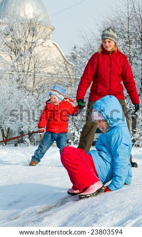 Happy family (mother with small boy) in winter snow covered courtyard