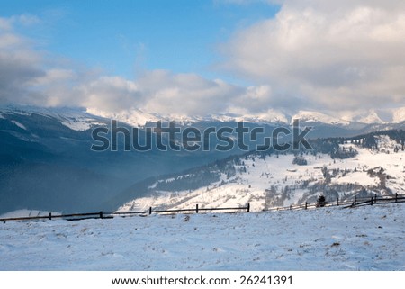 winter calm mountain landscape with rime and snow covered spruce trees.