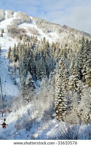 winter calm mountain landscape with snow-covered spruce-trees and ski ropeway