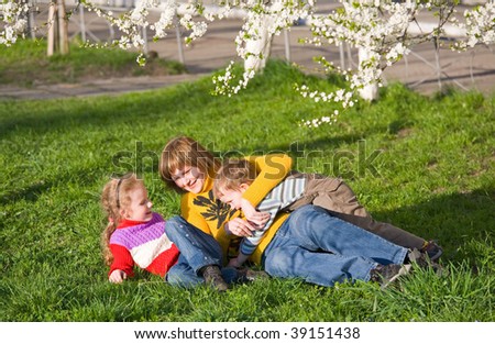Happy mother with small children in spring recreation ground