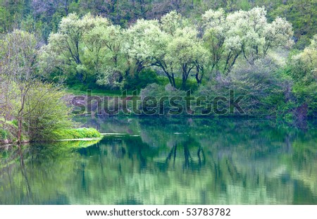 beautiful lake with spring trees and rocks mountain reflection in water surface