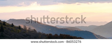 Autumn evening plateau landscape with lust golden-pink sunlight on mountains and evening glow in sky. Two shots stitch image.