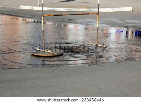 Breakthrough sewerage system. Water flows over the road from the sewer