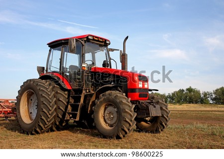 Color photo of a red tractor against the blue sky