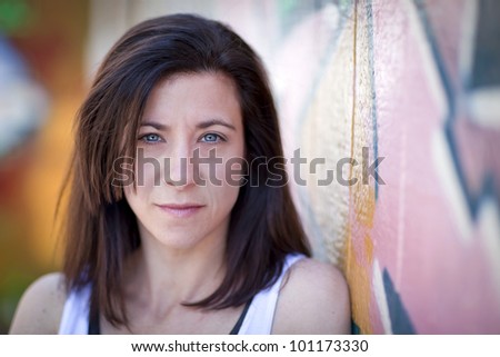 Beautiful woman in front of a graffiti covered wall