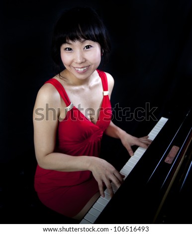 Beautiful asian woman playing the grand piano