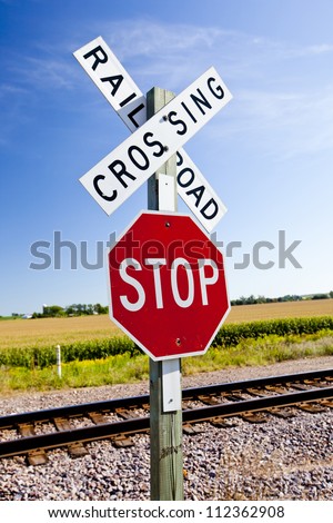 Railroad crossing and stop sign in farmland