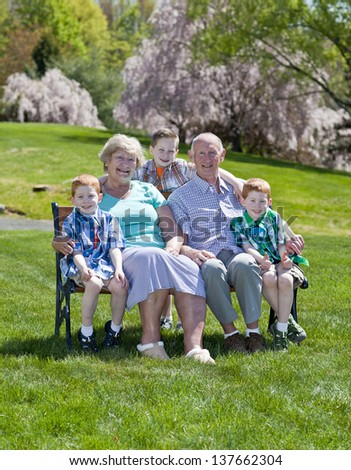 Happy grandparents with their grandson sitting outside