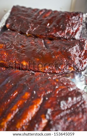 Racks of BBQ ribs on a hot grill
