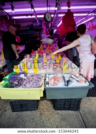 Fish market with unrecognizable shoppers making purchases in New York
