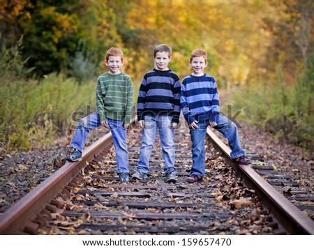 Three brothers standing an old rail tracks