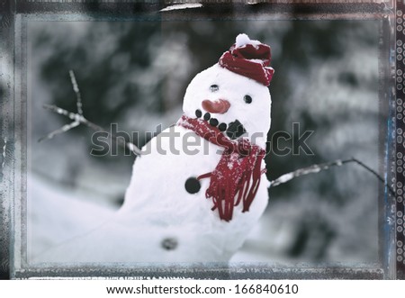 Snowman with red hat and scarf outside with vintage postcard frame